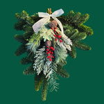 Frosty Christmas Swag Front view of the Frosty Door Swag featuring fresh evergreen foliage with frosted accents, red berries, pinecones, and a sheer gold ribbon bow, displayed against a green background. 4