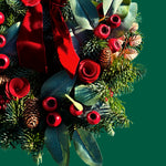 Red Rose and Rosehip Christmas Wreath Close-up of the Christmas wreath showing red rose decorations, pinecones, red berries, eucalyptus-style leaves, and textured evergreen foliage. 2