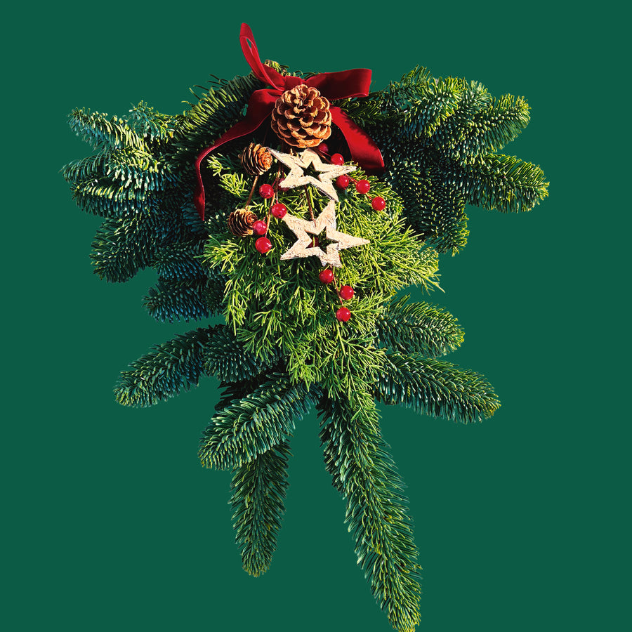 Star Christmas Swag Close-up of a festive evergreen swag with textured pine branches, pinecones, red berries and wooden star decorations on a green background. 3