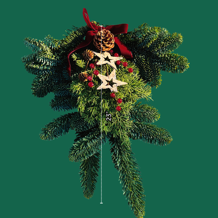 Star Christmas Swag Evergreen Christmas door swag measuring approximately 23 inches long, featuring pinecones, wooden stars, red berries and a burgundy ribbon, displayed on a green background. 4