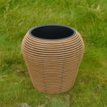 Mica Plant Pots - Light Brown Cane Medium-sized wicker plant pot with a natural tan and grey weave, featured on a grass 1